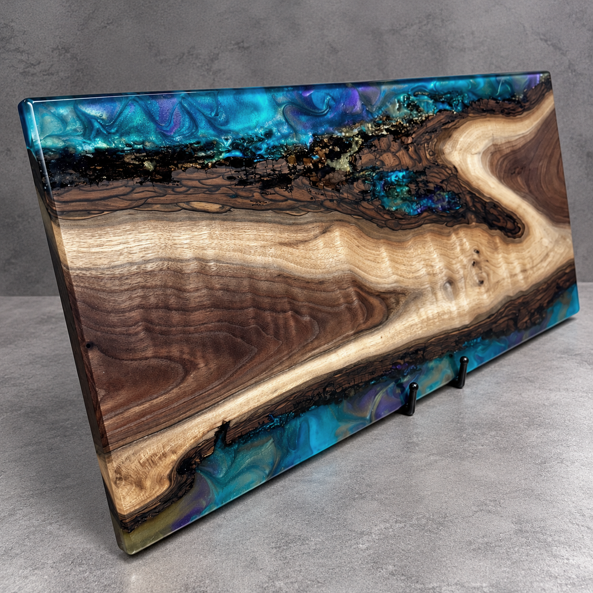 Handcrafted Midnight Aurora wood and epoxy art serving board featuring richly figured natural wood surrounded by swirling turquoise, electric blue, and violet resin along its upper and lower edges. Handmade by Trees To Home in Pennsylvania.