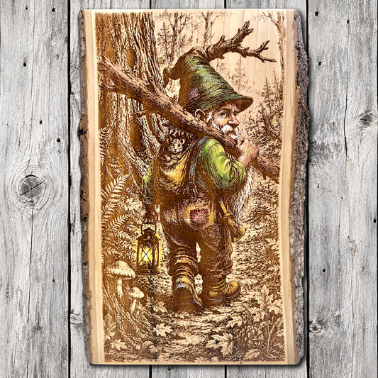 Hand-painted and laser engraved live edge wood wall art featuring a woodland gnome carrying a tree branch and glowing lantern, with a small mouse peeking from his backpack along a forest trail.